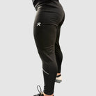 Side view of Super Weightlifting Second Pull Tights — black athletic leggings with reflective details and logo on the thigh.