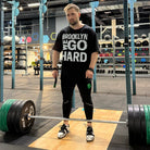 Gabriel Sincraian wearing Super Weightlifting 190 Heritage Tee while training with barbell in gym